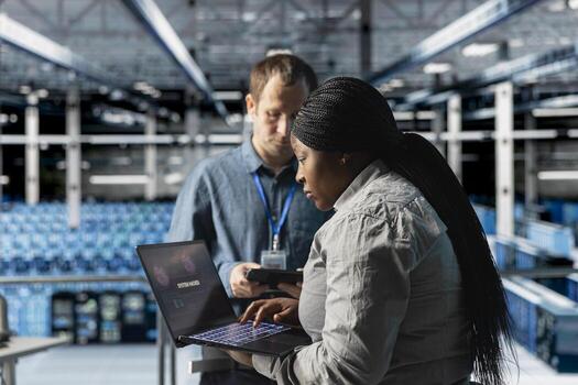 Server farm admins reviewing logs for anomaly detection after hacking attempt. Data center IT professionals verifying system integrity after failed intrusion attempt using laptop photo