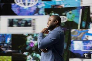 African American professional browses high tech environment with app icons, infographics and social networking feeds. Showcases big data on social media platforms, digital influence. photo