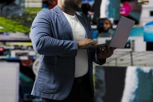Young black professional explores a tech driven environment with visual data, content feeds and applications. Symbolizing entertainment, social reach and digital transformation. photo