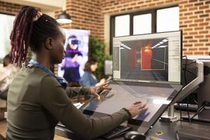 Black female professional using multi screens, working on editing and 3d modeling in a modern marketing agency. African american designer making project improvements on digital monitors. photo
