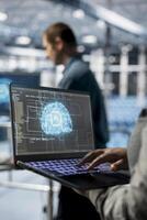 Close up of IT specialist in server hub using laptop to enhance AI model accuracy. Data center engineer using notebook to schedule routine maintenance for AI hardware components photo