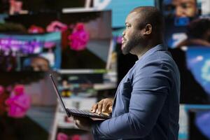 Black social media manager engaging with social network trends on screens, showcasing user interface and digital web platforms. Power of technology, influence and internet connection. photo