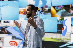 Male live presenter communicating to an online audience about branding strategy and social trends, using microphone during presentation to help enhance engagement and global reach. photo