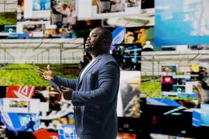 African american public speaker offers advice at a live convention, presenting digital influence and e commerce at the conference. Showcasing social media feeds for web communication. photo