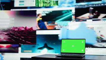 Green screen laptop in front of endless grid of streaming windows displaying mixed media. Mockup notebook and digital interface showing platform distributing content to global viewers photo