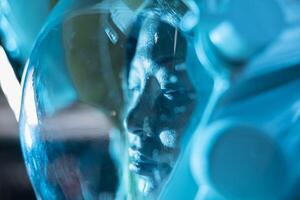 Extreme close up of unconscious cosmonaut wounded after space station disaster. Blue lights flashing over scientist facing medical hazard triggered by extreme cold in defective spaceship photo