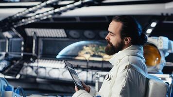 Cosmonaut troubleshooting spaceship hardware using tablet during mankind survival expedition. Researcher studying star charts on device during human expansion in space mission parameters photo
