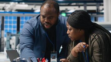 African american team of technical experts work on briefing in high tech power plant, planning future developments in renewable energy and industrial operations. Manufacturing process. Camera B. photo