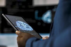 Young professional engineer focused on coding with tablet at an innovation hub, using programming language on terminal window for automation. Tech career in data science. Close up. photo