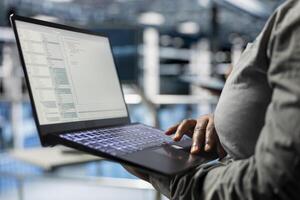 Close up of laptop used by data center software developer to upgrade system stability. Server hub IT professional coding, optimizing performance with device, configuring gear photo
