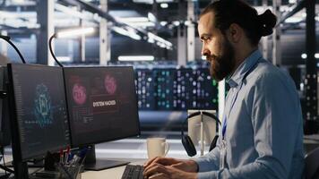 Server farm worker trying to fix hacked equipment systems and protect equipment. Data center engineer reacting to virus popup warning on computer screen, launching emergency response protocol photo