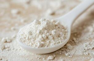 White flour mound in a white spoon photo