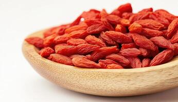 Dried red berries in a wooden bowl photo