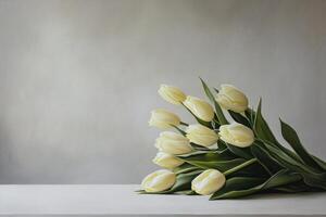 Pale yellow tulips on a light gray surface photo