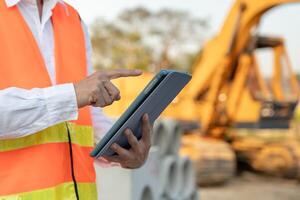 inspecting construction and quality assurance new house using a tablet. Engineers or architects or contactor work to build the house before handing it over to the homeowner photo