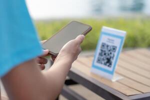 smartphone to scan QR code for order menu in cafe restaurant with a digital delivery. Choose menu and order accumulate discount. E wallet, technology, pay online, credit card, bank app photo