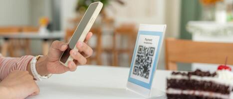 Woman use smartphone to scan QR code for order menu in cafe restaurant with a digital delivery. Choose menu and order accumulate discount. E wallet, technology, pay online. credit card. photo