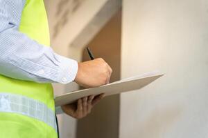 inspector or engineer is inspecting construction and quality assurance new house using a checklist. Engineers or architects or contactor work to build the house, photo