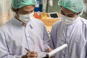 supervisor food or beverages technician inspection about quality control food or beverages before send product to the customer. Production leader recheck ingredient and productivity. photo