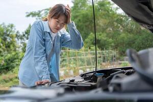 Stress Woman look engine during car accident . Find garage to get car fixed during country tour, waiting for help, emergency. photo