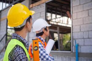 inspector or engineer is inspecting construction and quality assurance new house using a checklist. Engineers or architects or contactor work to build the house before handing photo