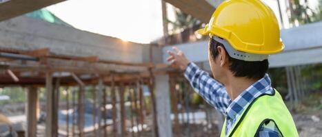 inspector, engineer, Foreman or contactor point on construction for inspect the quality of his work. architects work to build the house before handing it over to the homeowner. Develop new estate. photo