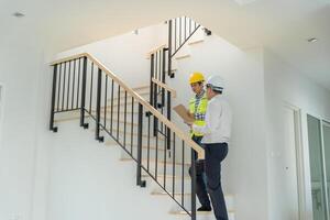 inspector engineer is inspecting construction and quality assurance new house using a tablet. Engineers or architects or contactor work to build the house before handing it over to the homeowner photo