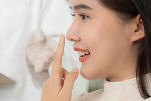 smile and happy after surgery, surgical procedure that involve altering shape of nose, doctor examines patient nose before rhinoplasty, medical assistance, health photo
