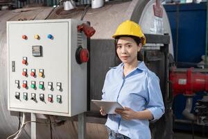 factory managers wearing safety helmet inspect the machines in the production line. The inspector opened the machine to test the system to meet the standard. machine maintenance photo