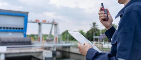 maintenance and inspector. Maintenance engineers are using walky talky to inform the results of inspection of buildings and structures. Irrigation engineers are explor sluice systems. photo