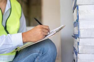 inspector or engineer is inspecting construction house using a checklist. Engineers and architects or contactor count materials for construction. Building, check, insurance house. quality, photo