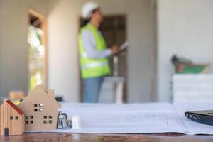 inspector or engineer is inspecting construction and quality assurance new house using a blue print. Engineer or architects or contactor work to build the house before handing photo