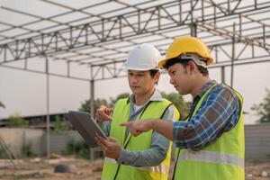 inspector or engineer is inspecting construction and quality assurance new house using a tablet. Engineers or architects or contactor work to build the house, photo