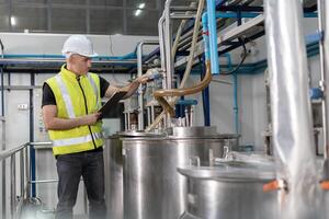 managers wearing safety helmet inspect the machines in the production line. Utility inspector check machine and test the system to meet the standard. machine, maintenance. photo