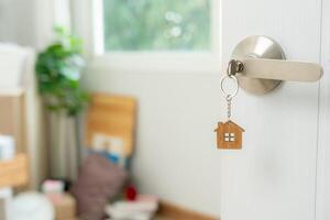 Moving house, relocation. The key was inserted into the door of the new house, inside the room was a cardboard box containing personal belongings and furniture. move in the apartment and condominium photo