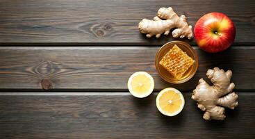 A wooden table with ginger, lemon, honey and apples photo