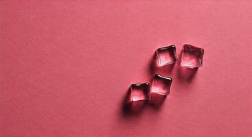 Glass Ice Cubes on Pink Background with Shadow Effect photo