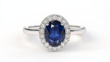 A luxurious white gold ring features an oval deep blue gemstone framed with a halo of glistening diamonds, reflecting sophistication photo