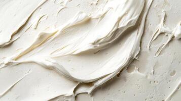 Moist cream is spread across a light surface, highlighting its glossy texture and rich consistency under soft light conditions photo