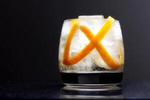 Refreshing cocktail with ice cubes and an orange twist garnished, presented against a clean white background photo