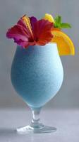 A refreshing blue curacao cocktail featuring a combination of tropical colors, garnished with a hibiscus flower and slices of citrus fruit photo