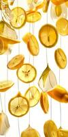 Sliced lemons are creatively displayed by hanging them against a white background, showcasing their bright colors and textures photo
