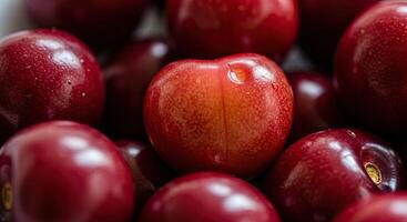 Macro shot of ripe red plums showcasing their vibrant color and smooth texture photo