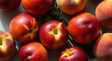 Close-up shot of ripe nectarines with vibrant red and yellow hues on a surface photo