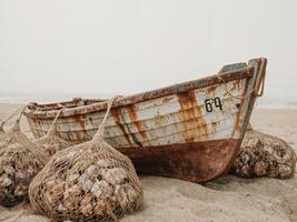 An old boat on the beach with a net photo