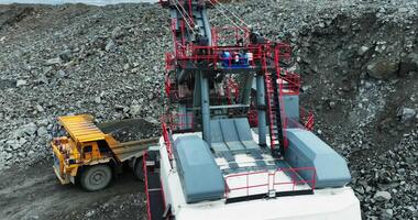 Giant excavator loading dump truck in open pit mine. Stock clip video