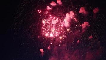Red fireworks exploding in the night sky during a celebration photo