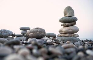 Stacked stones on a pebbled beach creating a tranquil and balanced natural scene photo