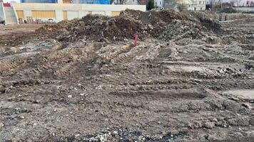 The image captures a dynamic view of a construction site featuring uneven and rugged terrain along with earth mounds photo