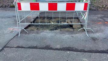 A designated repair site for a pothole has been properly marked with a safety barrier to prevent any accidents photo